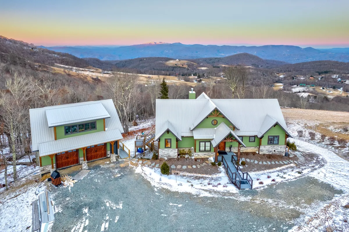 This exterior shot captures both the main house and the guest house set amid rolling mountains. The scene suggests opportunities for outdoor gatherings, exploration, and stargazing, while the presence of the homes emphasizes the blend of modern living and natural surroundings.